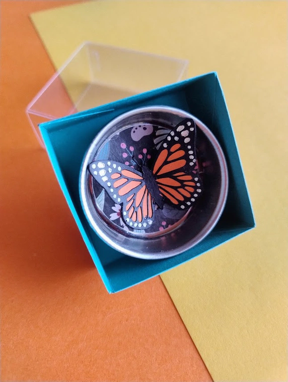 Vista imán mariposa monarca con empaque
